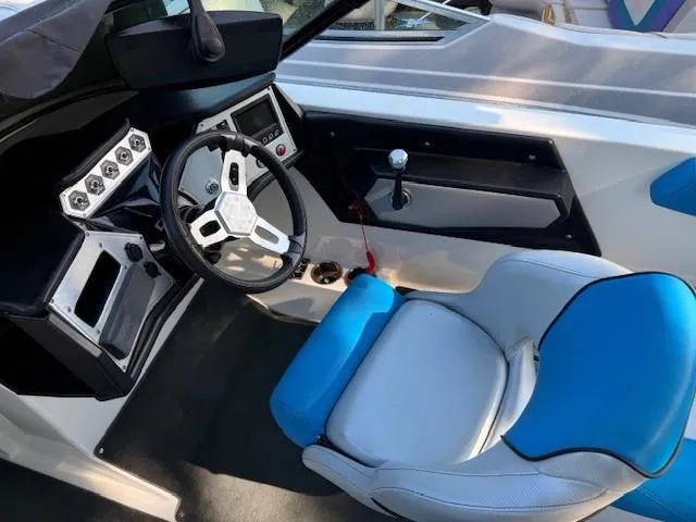 Slide: The Image of 2017 MasterCraft NXT22 boat cockpit with steering wheel and blue-accented seat. - 12