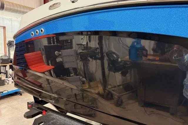 Slide: The Image of 2017 MasterCraft NXT22 boat in a workshop, showcasing sleek blue and black design. - 37