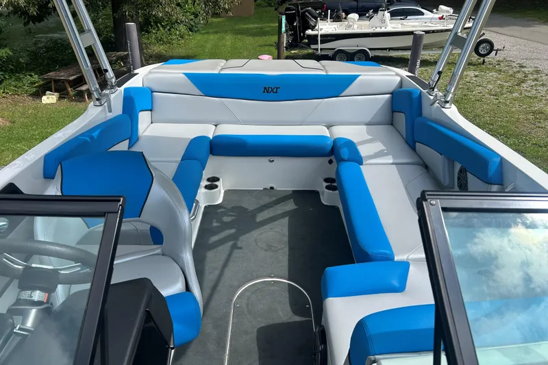 Slide: The Image of 2017 MasterCraft NXT22 boat interior with blue and white seating, open bow design. - 40