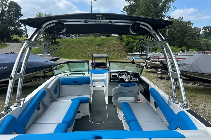 Slide: The Image of 2017 MasterCraft NXT22 boat with blue and white interior, parked outdoors. - 46