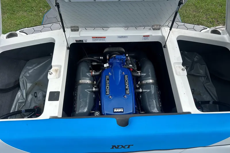 Slide: The Image of 2017 MasterCraft NXT22 boat engine compartment with Ilmor engine, open hatches, and storage areas. - 48