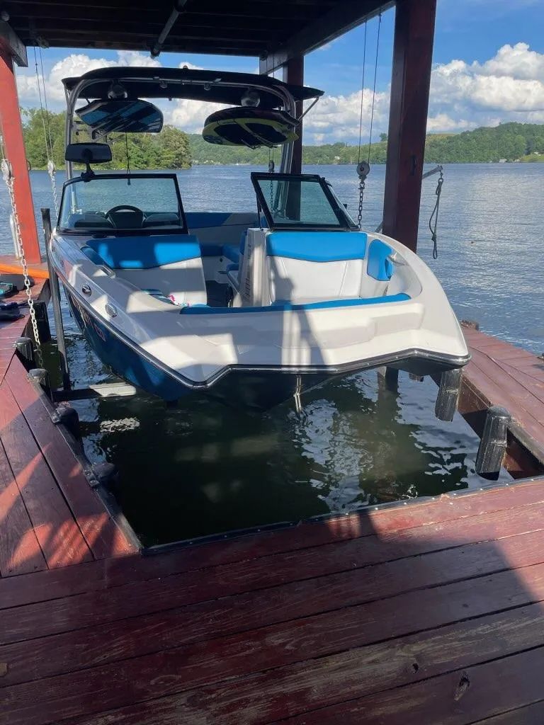 Slide: The Image of 2017 MasterCraft NXT22 boat docked on a sunny lake with blue interior. - 5