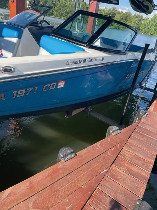 Slide: The Image of 2017 MasterCraft NXT22 boat docked on a lake with blue and white design. - 7