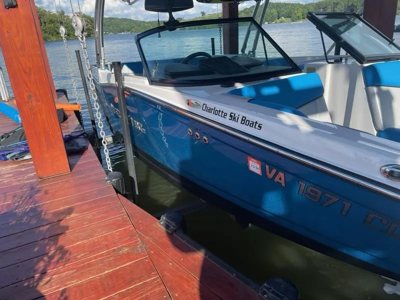 Slide: The Image of 2017 MasterCraft NXT22 boat docked by a wooden pier on a sunny day. - 8