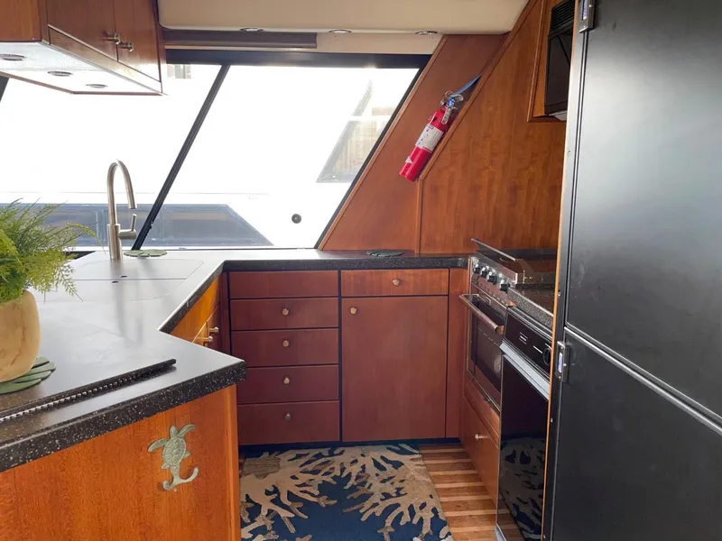 Slide: The Image of 1994 Bayliner 4788 Pilot House Motoryacht kitchen with wood cabinetry and modern appliances. - 16