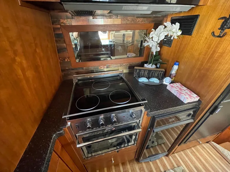 Slide: The Image of 1994 Bayliner 4788 yacht kitchen with stove, countertop, and decorative elements. - 19