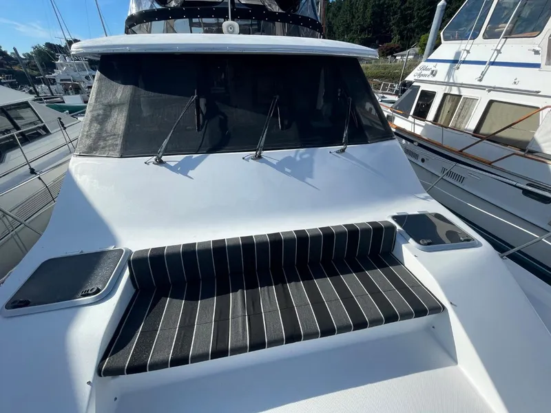 Slide: The Image of 1994 Bayliner 4788 Pilot House Motoryacht with striped seating, docked at a marina. - 2