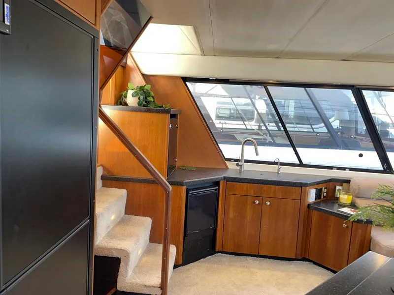 Slide: The Image of Interior of 1994 Bayliner 4788 Pilot House Motoryacht with modern kitchen and staircase. - 24