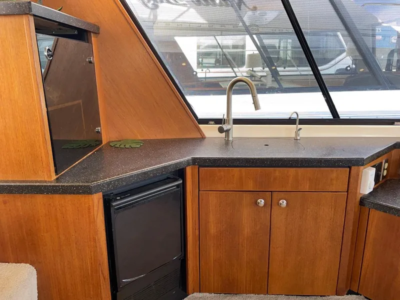 Slide: The Image of 1994 Bayliner 4788 Pilot House Motoryacht interior with wooden cabinetry and modern sink. - 25
