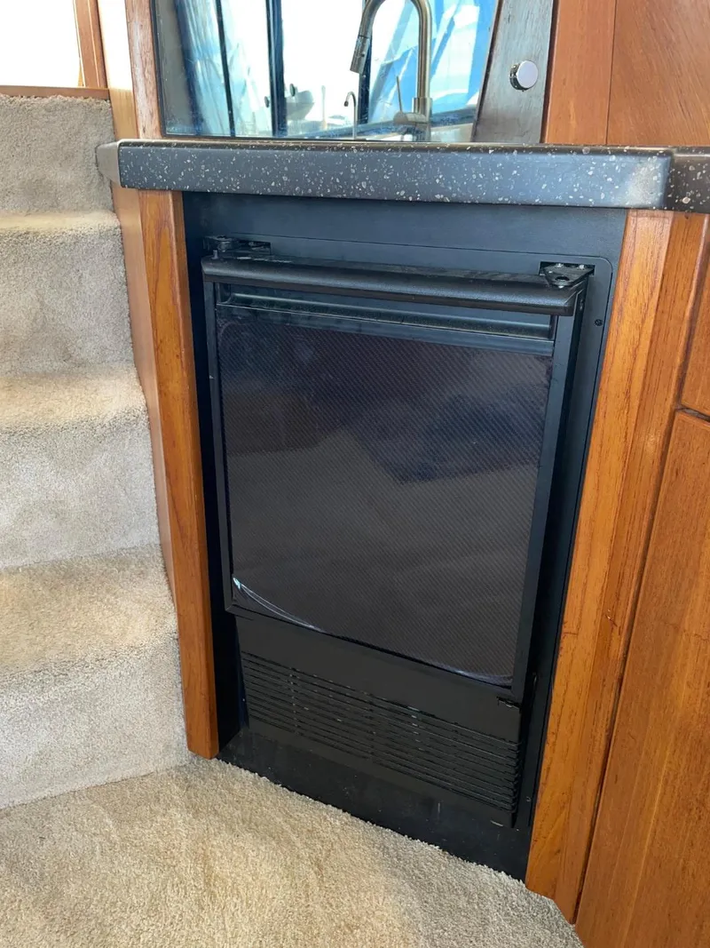 Slide: The Image of 1994 Bayliner 4788 Pilot House Motoryacht interior with compact black refrigerator. - 27