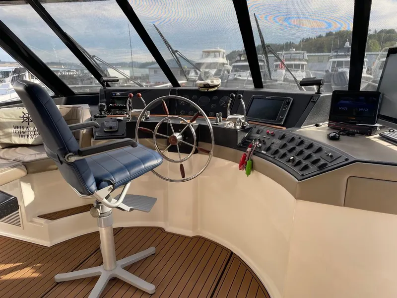 Slide: The Image of 1994 Bayliner 4788 Pilot House Motoryacht helm with steering wheel and navigation controls. - 28