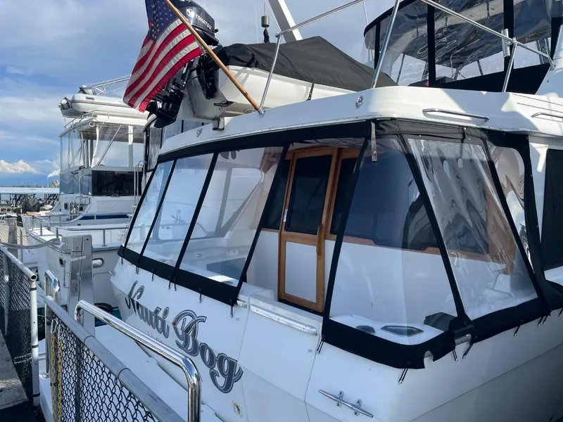 Slide: The Image of 1994 Bayliner 4788 Pilot House Motoryacht docked with American flag displayed. - 3