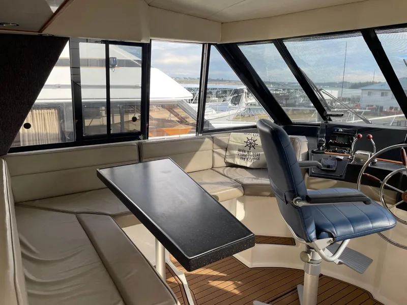 Slide: The Image of 1994 Bayliner 4788 Pilot House Motoryacht interior with seating, table, and helm station. - 30
