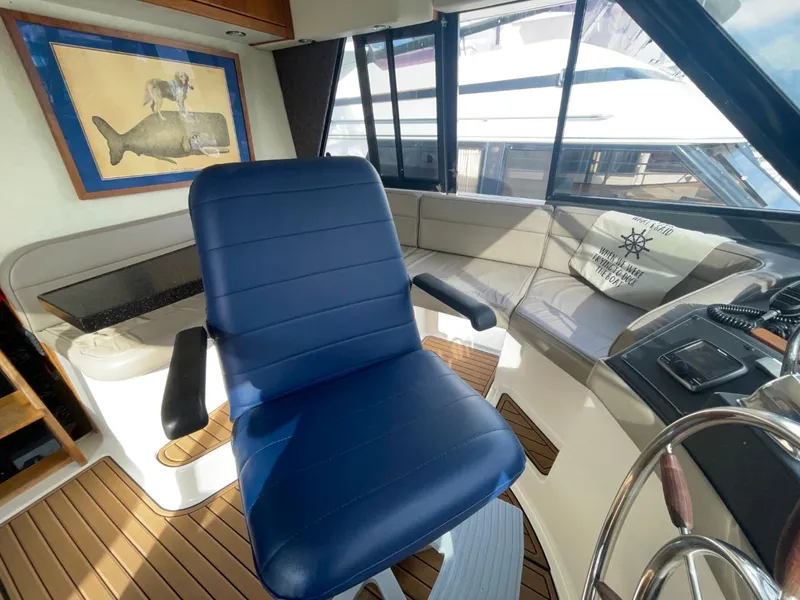 Slide: The Image of 1994 Bayliner 4788 Pilot House Motoryacht interior with blue captain's chair and nautical decor. - 31