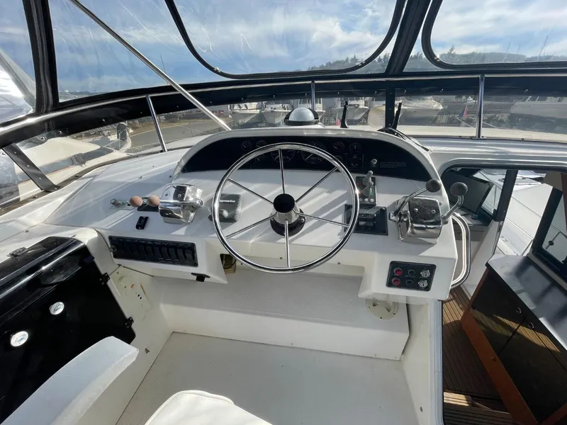 Slide: The Image of 1994 Bayliner 4788 Pilot House Motoryacht helm with steering wheel and controls. - 45