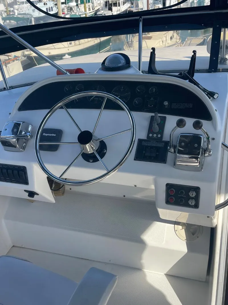 Slide: The Image of 1994 Bayliner 4788 Pilot House Motoryacht helm with steering wheel and controls. - 46