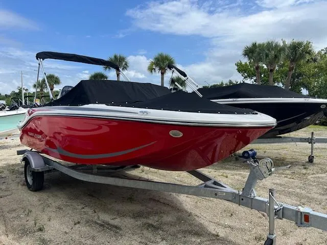 The Image of 2025 Bayliner Element M17 boat in vibrant red on a trailer, parked outdoors. - 0