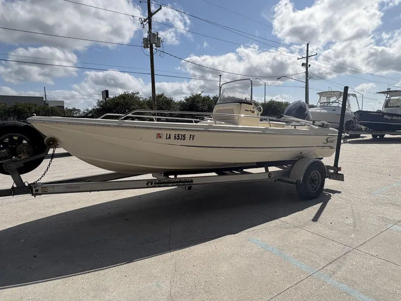 Slide: The Image of 2005 Scout 17 boat on trailer under cloudy sky. - 8