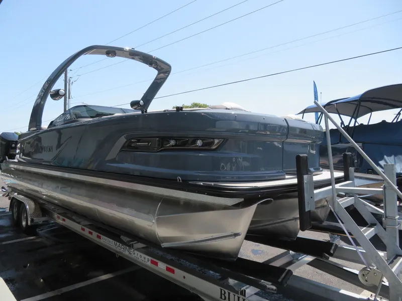 Slide: The Image of 2026 Avalon Excalibur Elite Windshield boat on trailer, sleek design, outdoor display. - 6