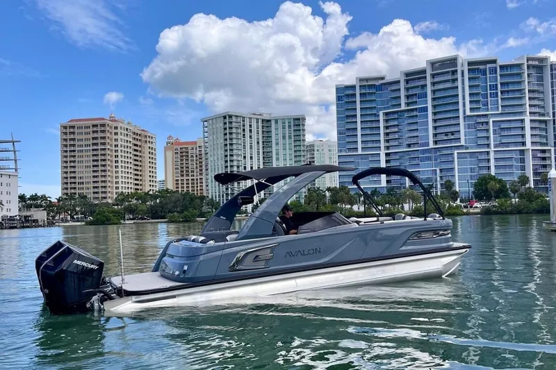 Slide: The Image of Luxury Avalon 2785 Excalibur Elite Tri-toon boat in Sarasota, FL, with cityscape backdrop. - 7