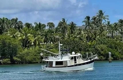 The Image of 1993 Kadey-Krogen Krogen 42 cruising on a tropical waterway with lush palm trees. - 1