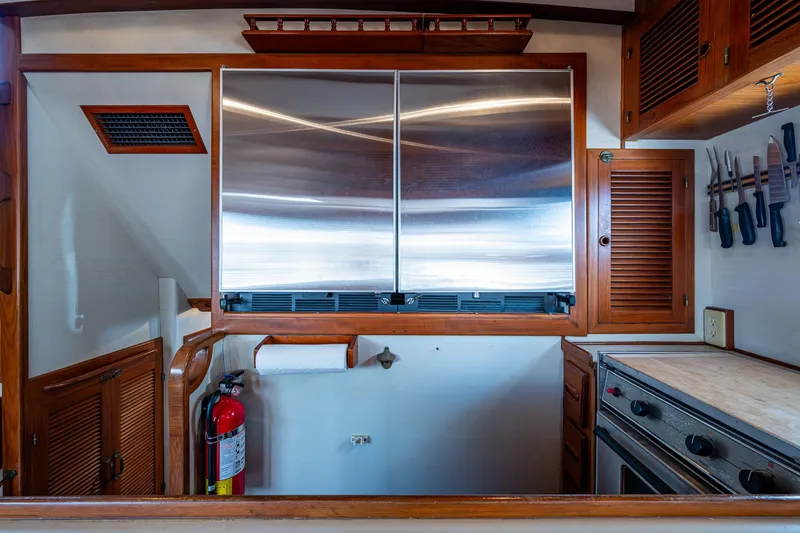 Slide: The Image of 1993 Kadey-Krogen Krogen 42 yacht kitchen with stainless steel fridge, wooden cabinets, and knife rack. - 12