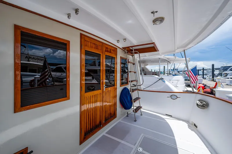 Slide: The Image of Kadey-Krogen 1993 Krogen 42 yacht deck with wooden doors and marina view. - 3