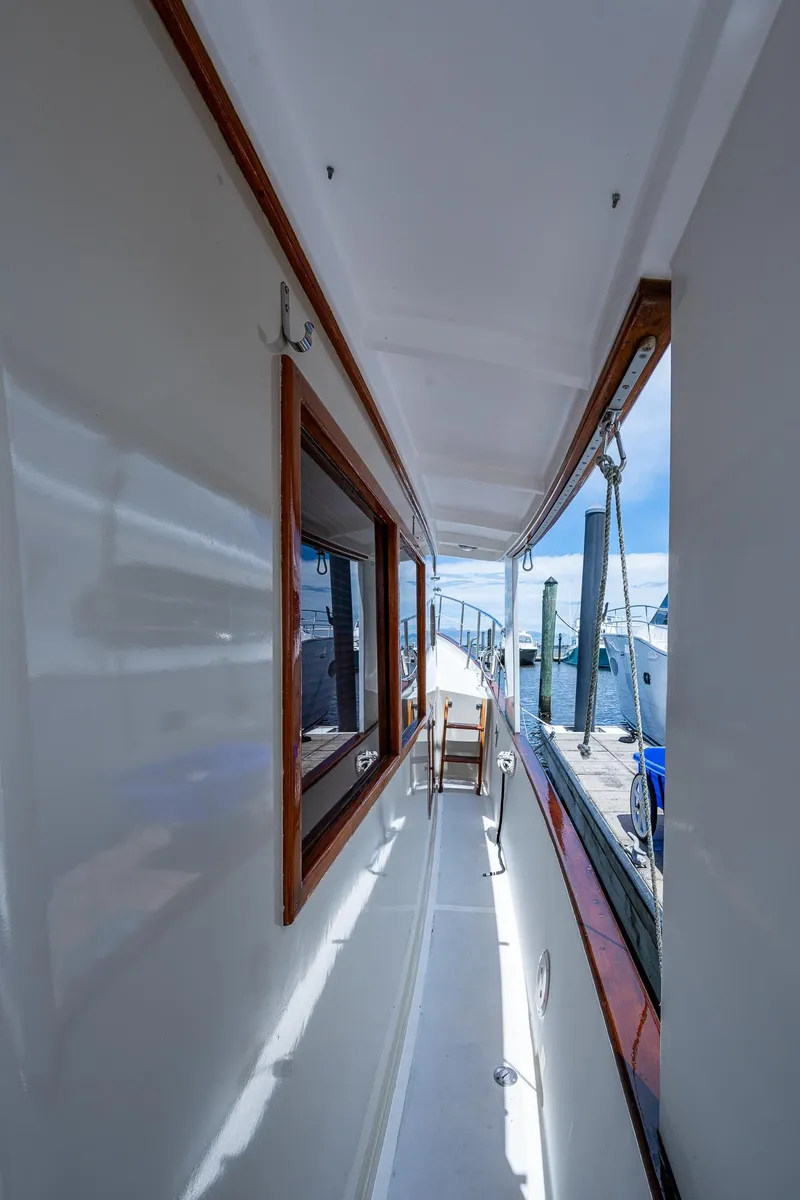 Slide: The Image of Side deck of 1993 Kadey-Krogen Krogen 42 yacht, featuring polished wood and marina view. - 38