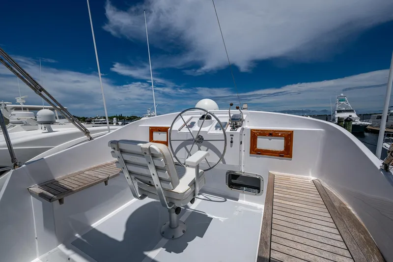 Slide: The Image of Helm of 1993 Kadey-Krogen Krogen 42 yacht with steering wheel and seating under blue sky. - 44