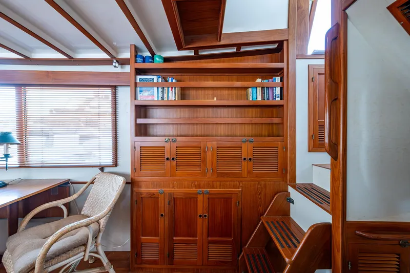 Slide: The Image of Interior of 1993 Kadey-Krogen Krogen 42 yacht with wooden shelves and wicker chair. - 9