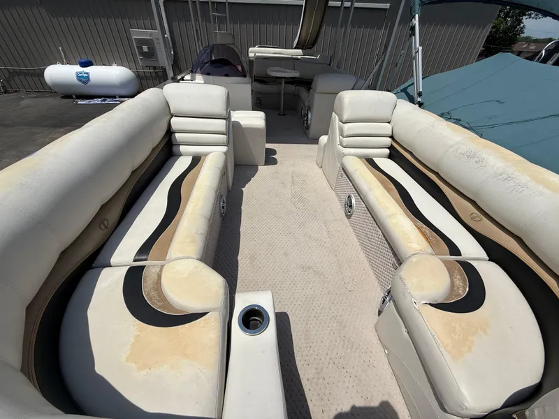 Slide: The Image of 2011 Tahoe Pontoon Double Decker interior with beige seating and cup holders. - 13