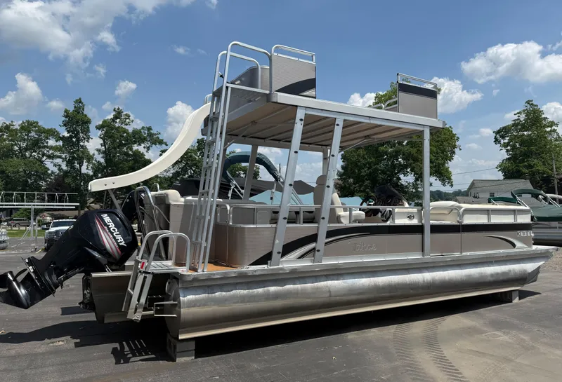 Slide: The Image of 2011 Tahoe Pontoon Double Decker with slide and Mercury engine, parked outdoors. - 2