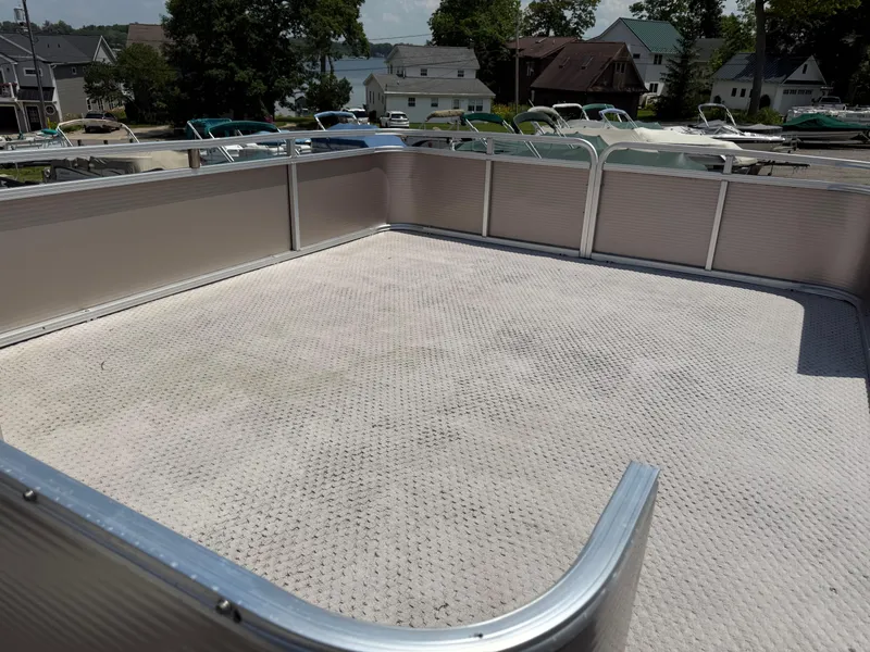 Slide: The Image of 2011 Tahoe Pontoon Double Decker upper deck with railing, overlooking a marina. - 5