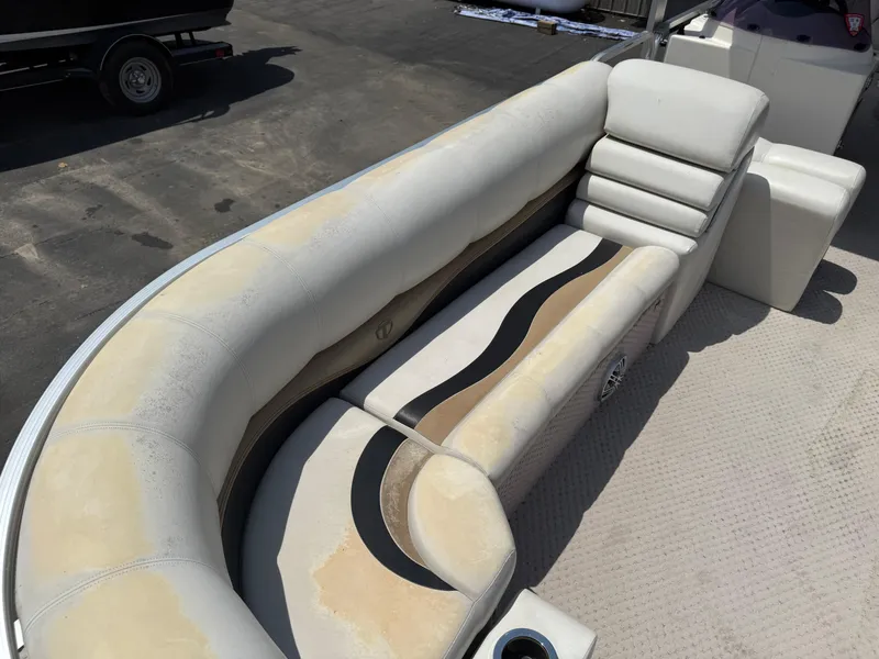 Slide: The Image of 2011 Tahoe Pontoon Double Decker boat interior with beige seating and cup holder. - 9