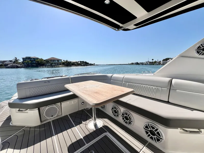 Slide: The Image of 2022 Sea Ray SLX 400 OB boat with luxurious seating and scenic waterfront view. - 11