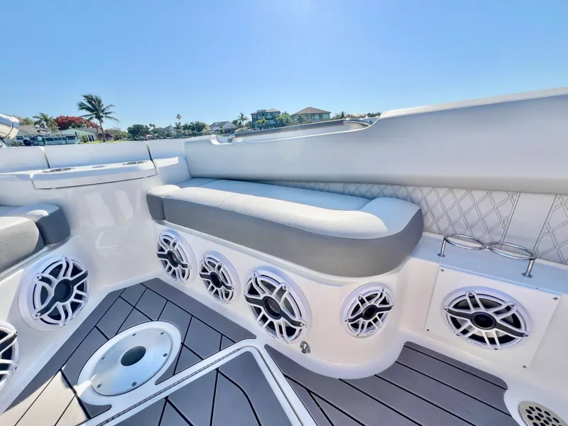 Slide: The Image of 2022 Sea Ray SLX 400 OB boat interior with cushioned seating and multiple speakers. - 29