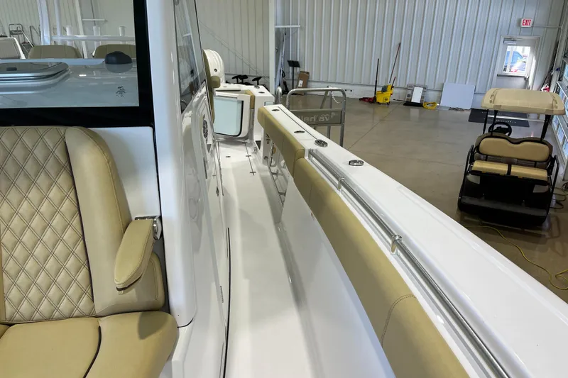 Slide: The Image of 2025 Sportsman Open 352 Center Console interior with beige seating in a showroom. - 11