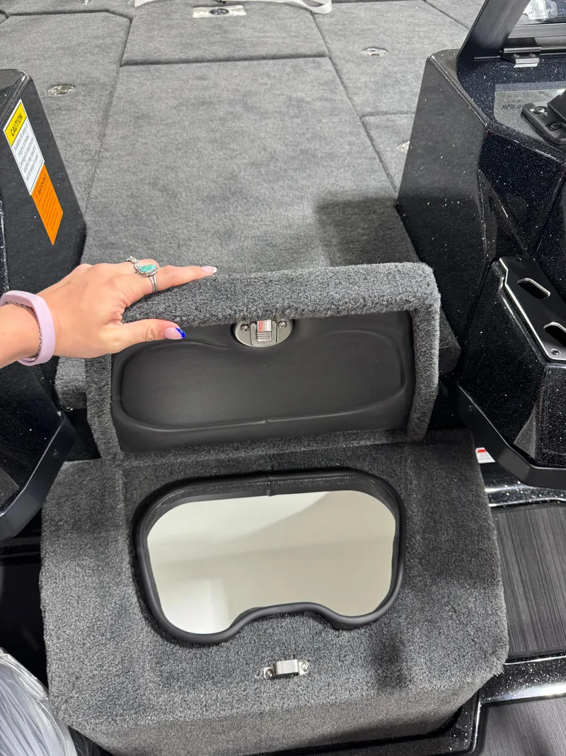Slide: The Image of 2025 Skeeter WXR 2260 boat storage compartment with carpeted interior and hand opening lid. - 11