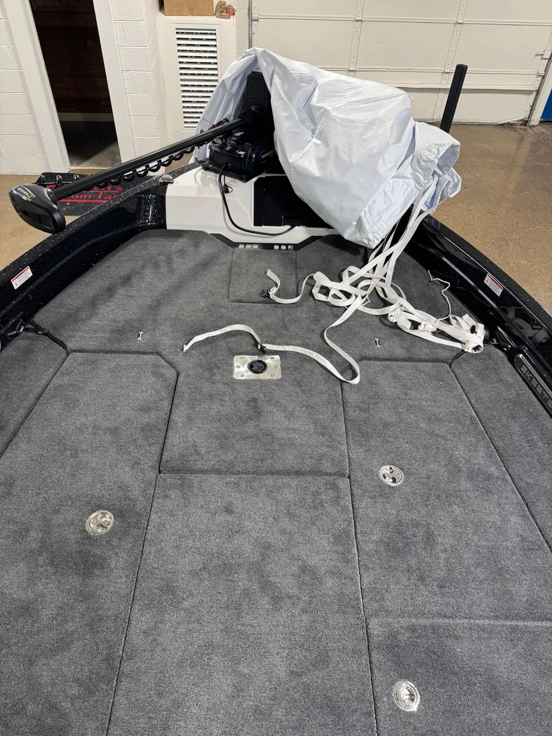 Slide: The Image of 2025 Skeeter WXR 2260 boat deck with gray carpet and covered equipment. - 13