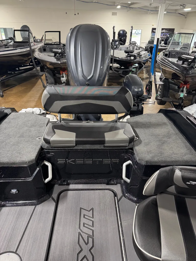 Slide: The Image of 2025 Skeeter WXR 2260 boat interior with seating and motor, displayed in showroom. - 4
