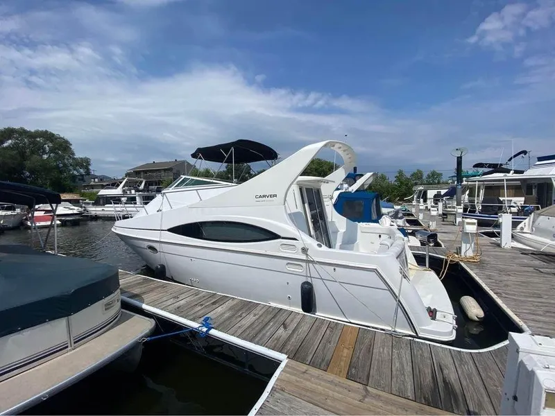 Slide: The Image of 1999 Carver 350 Mariner yacht docked at marina under blue sky. - 19