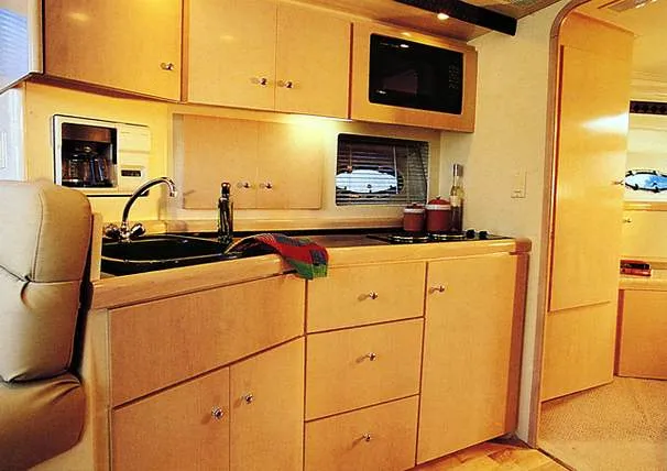 Slide: The Image of 1999 Carver 350 Mariner kitchen with wooden cabinets, sink, and microwave. - 5