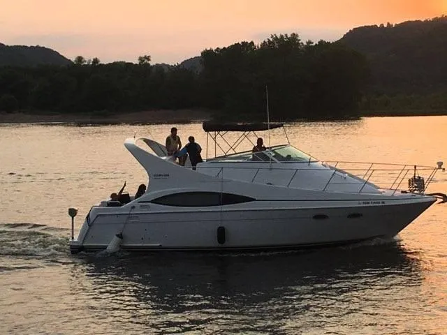 Slide: The Image of 1999 Carver 350 Mariner yacht cruising on a serene lake at sunset. - 12