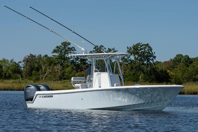 Slide: The Image of 2026 Contender 25T boat on calm water with trees in the background. - 2