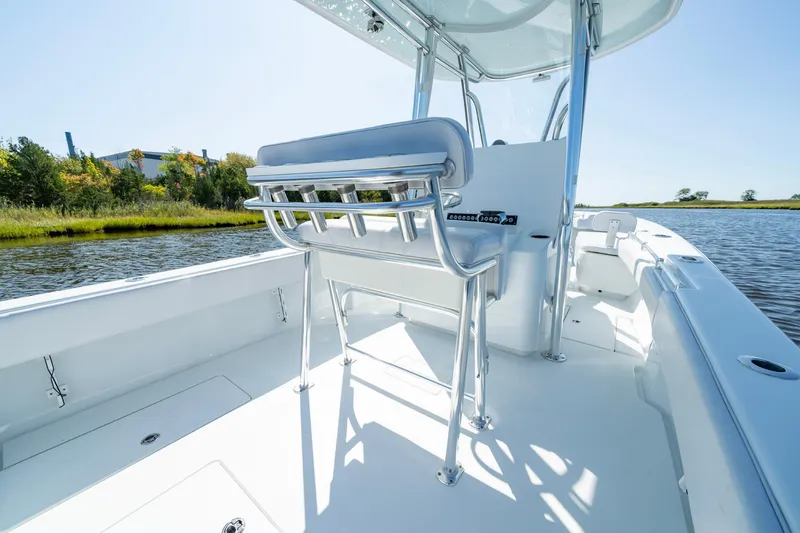 Slide: The Image of 2026 Contender 25T boat interior with sleek seating and console, on a calm waterway. - 7