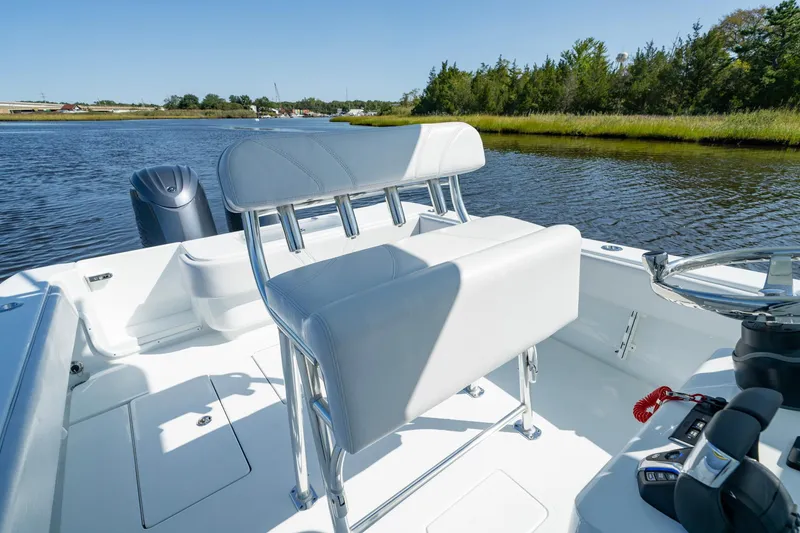 Slide: The Image of 2026 Contender 25T boat interior with sleek seating and controls on a calm river. - 8