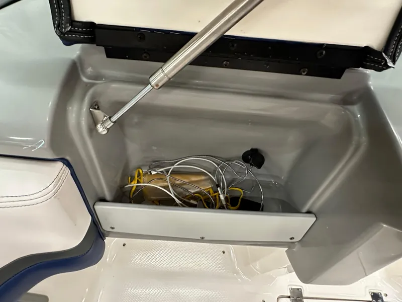 Slide: The Image of Storage compartment in a 2019 Chaparral Vortex 203 VR boat, containing wires and accessories. - 48