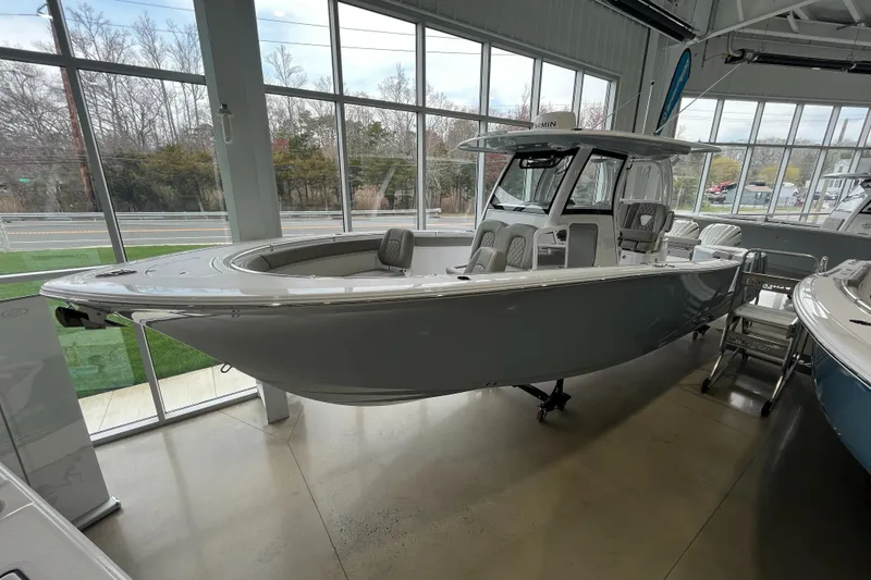 Slide: The Image of 2025 Sportsman Open 302 Center Console boat displayed in a showroom. - 0