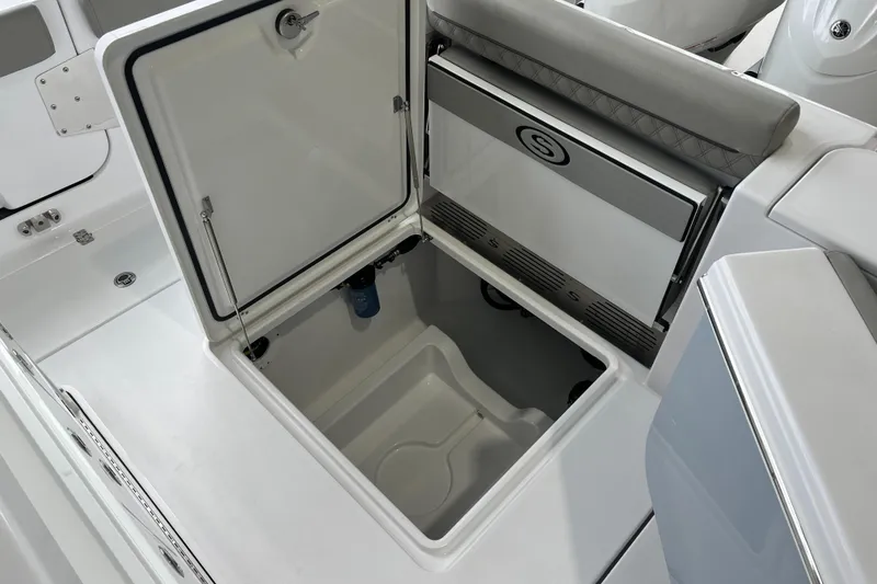 Slide: The Image of 2025 Sportsman Open 302 Center Console storage compartment with open lid, showcasing interior space. - 6
