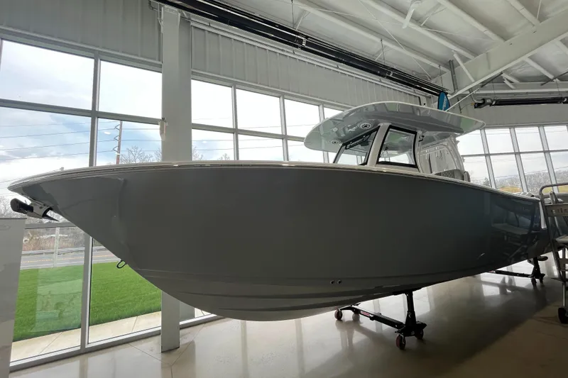 Slide: The Image of 2025 Sportsman Open 302 Center Console boat displayed indoors. - 8